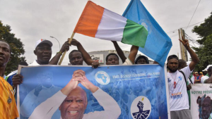 Demonstrators wave the national flag and hold a banner of PPA-CI party leader Laurent Gbagbo during a protest in Abidjan, Ivory Coast, Saturday, Aug. 9, 2025.© AP Photo